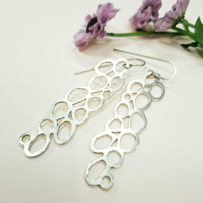 Boucles d'oreilles longues et ajourées. Système dormeuse. Création en argent fabriquée par la bijoutière à Lyon